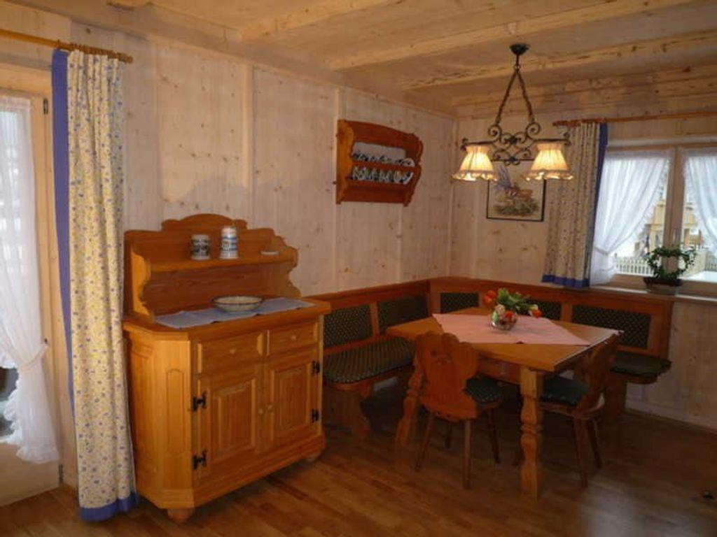 Ein Esszimmer mit Holzeinrichtung, einer Bank, einem Tisch und einem Schrank.