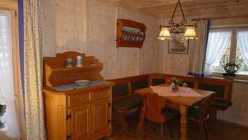 Ein Esszimmer mit Holzeinrichtung, einer Bank, einem Tisch und einem Schrank.