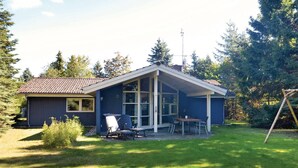 A single-story house with a covered patio, a small shed, and a lawn. - Beautiful home in Væggerløse with sauna (Væggerløse)