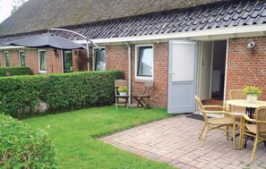 Experience a charming, retreat with a patio area, round table, and wicker chairs.