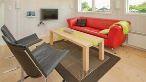 A modern living room with a red leather sofa, two black chairs, a wooden coffee table, and a TV mounted on the wall. - Awesome home in Haderslev with WiFi (Haderslev)
