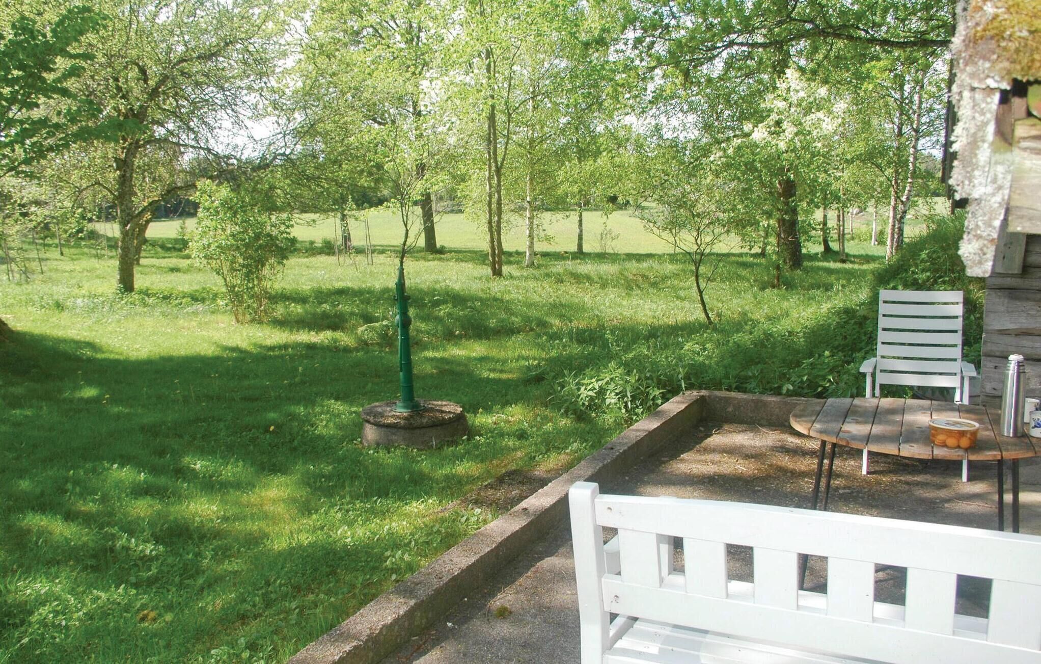 A patio area with a white bench, a small table, and a metal water bottle.