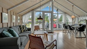 A spacious loft with a high ceiling, a dining area, and a seating area with a sofa and chairs.