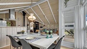 A dining area with a white table, black chairs, and teal candle holders.