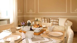 A dining area with a table set for breakfast, including plates, cups, and a decorative centerpiece. - Holiday apartment mit Pool (Montecarlo Lucca)