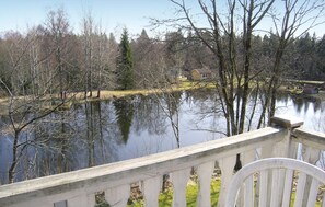 Une vue sur le lac, avec une terrasse en bois et une chaise.