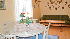 En matplats med ett runt bord, stolar och en grön soffa.