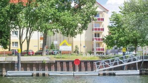 Une vue sur la rivière, avec un pont, un bâtiment doté de balcons et une enseigne.