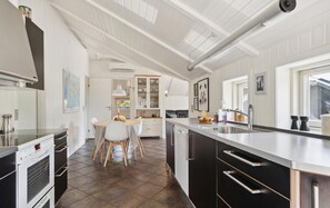 Enjoy cooking in this well-equipped kitchen with a central island, stainless steel sink, and range of appliances.