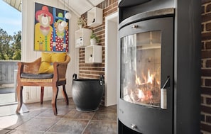 Relax by the warm glow of the wood-burning stove in this inviting outdoor seating area.