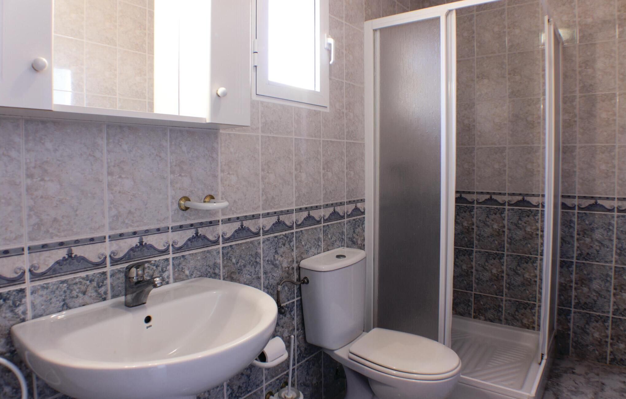 A bathroom with a sink, toilet, and shower.