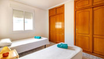 Relax in a serene space with a large window, two spacious wardrobes, and a comfortable ottoman.