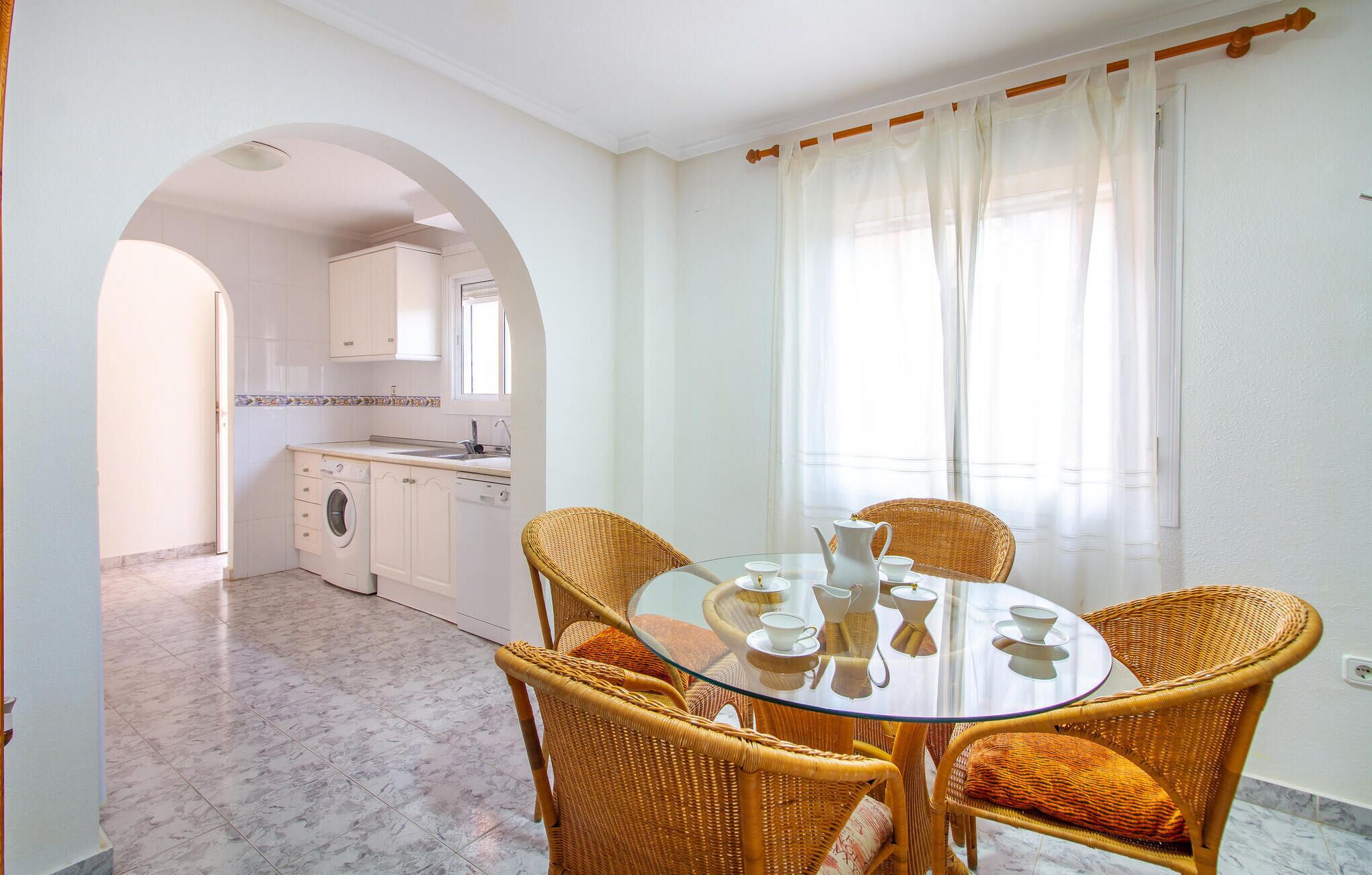Une cuisine moderne avec des meubles blancs, un lave-linge et un évier.
