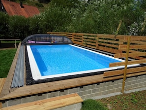 Ein rechteckiger Pool mit Holzboden und einer Ziegelwand.