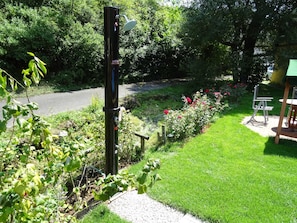 Ein Garten mit Wasserspiel, einem Weg und einer Sitzgruppe.