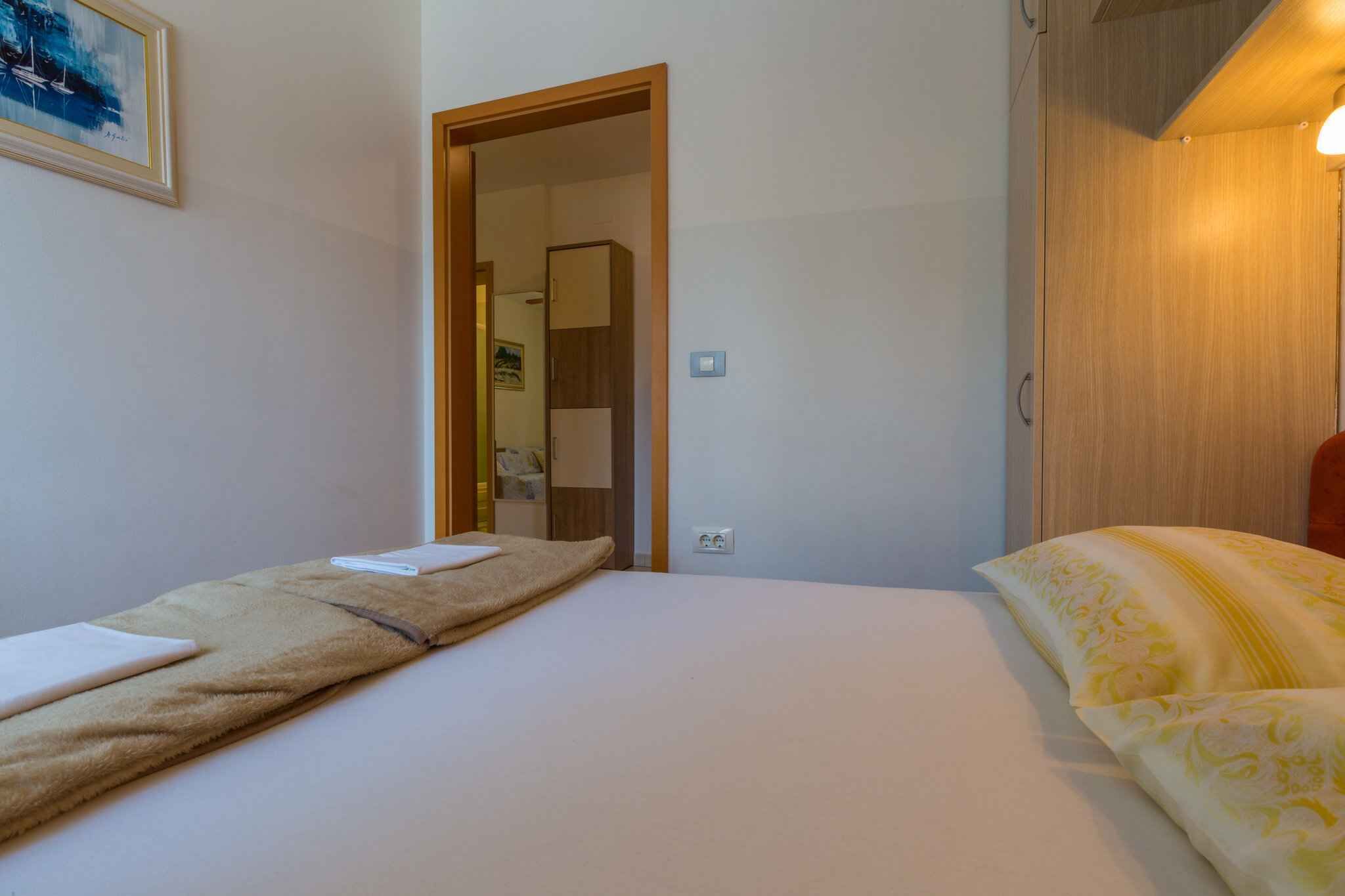 Una camera da letto con un letto, un comodino e una porta che dà su un'altra stanza.
