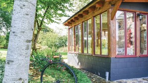A wooden cabin with large windows, a bicycle, and a tree. - Beautiful home in Montaudin with WiFi (Montaudin)