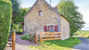 A stone building with a wooden gate, a small window, and a chimney. - Beautiful home in Montaudin with WiFi (Montaudin)