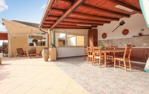 A spacious patio with a wooden table and chairs, a large vase, and a wooden chair. - Awesome home in Menfi AG (Menfi AG)