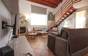 A living room with a fireplace, wooden furniture, a staircase, and a large window. - Awesome home in Menfi AG (Menfi AG)