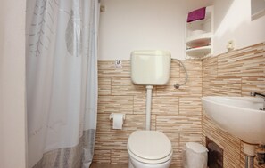 A small bathroom with a toilet, a sink, and a shower curtain. - Awesome home in Menfi AG (Menfi AG)
