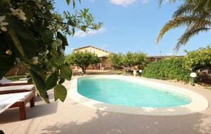 A swimming pool surrounded by a patio area with lounge chairs and a building in the background. - Awesome home in Menfi AG (Menfi AG)