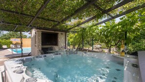 A hot tub with a pergola overhead, a pool, and outdoor furniture. - Cozy home in Dugopolje (Dugopolje)