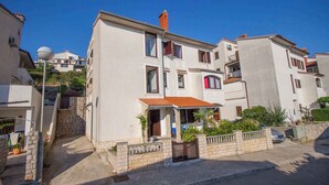 A residential building with a stone staircase, a red-tiled roof, and a small garden area. - Holiday apartment only 150 m to the Adriatic Sea (Mali Lošinj)