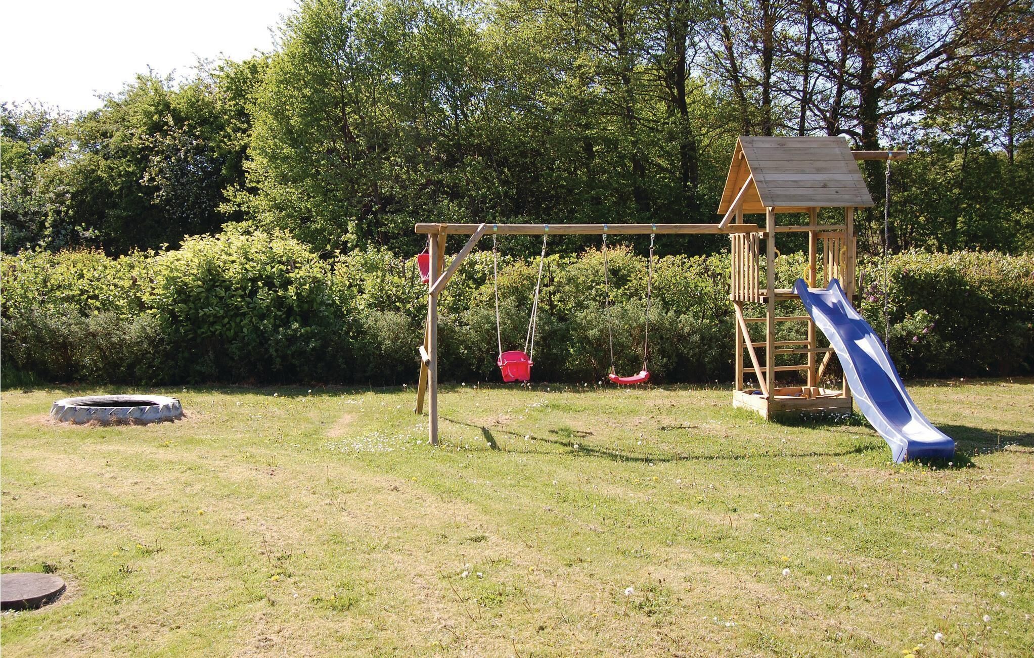 Une aire de jeux avec des balançoires, un toboggan et une petite structure en bois.