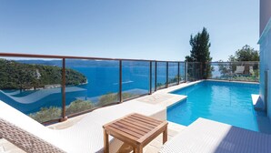 A private pool with a clear view of the sea and surrounding landscape.