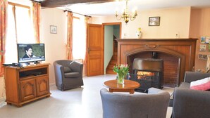 A living room with a fireplace, a television, and a sofa. - 4 bedroom gorgeous home in Parfondeval (Parfondeval)