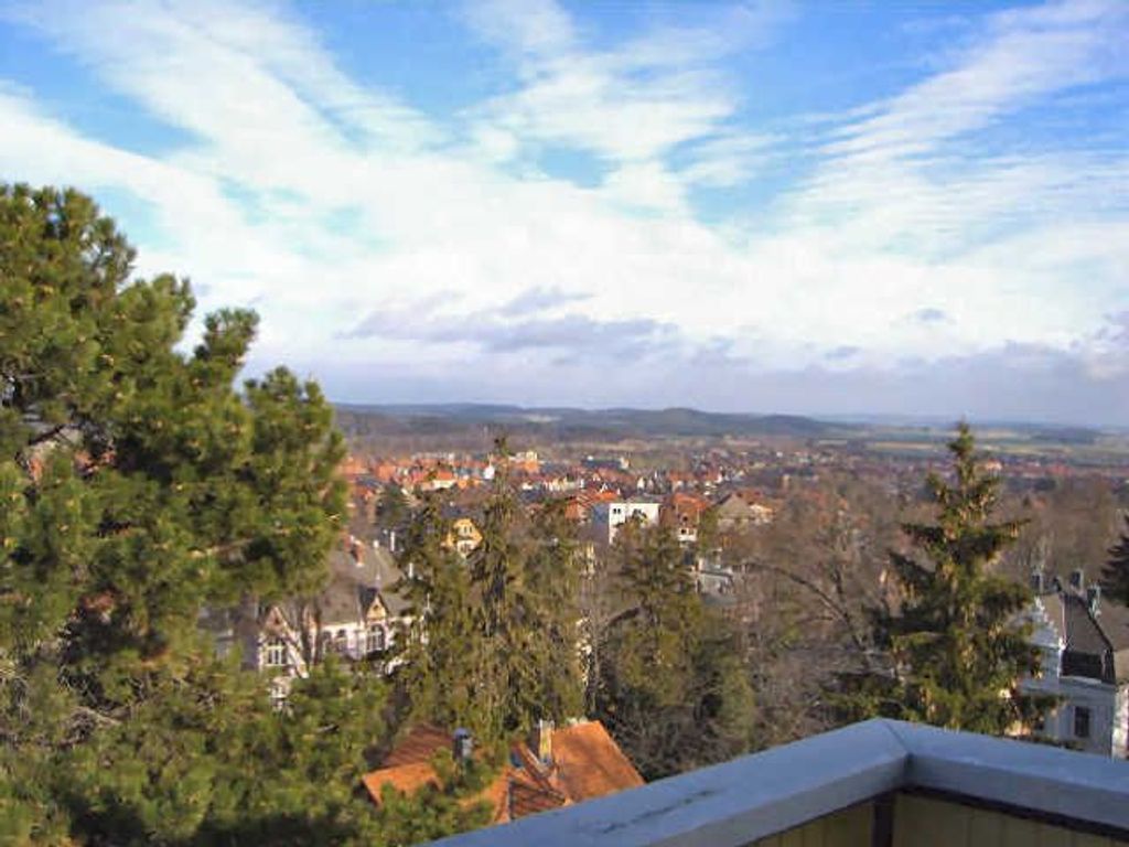 Ein weiter Panoramablick auf eine Stadt mit Gebäuden, Bäumen und blauem Himmel.