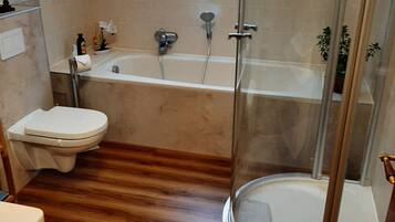 Une salle de bain avec une baignoire, des toilettes et une douche.