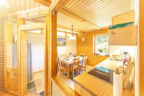 Un intérieur en bois comprenant un coin repas, une cuisine et une fenêtre bien visible.