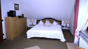 A bedroom with a bed, bedside tables, a wardrobe, a small table with a lamp, and a chair. - Vacation apartment Will, Germany (Walkenried)