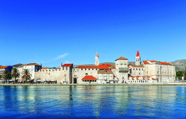 A historic waterfront cityscape with prominent buildings, including a castle-like structure with red roofs and a tall tower. - Stunning apartment in Trogir with WiFi (Trogir)