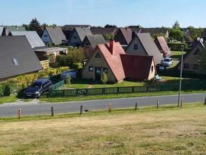 Zona residencial com casas, uma rua e um carro estacionado.
