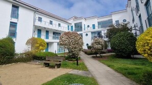 A building with a central courtyard, surrounded by greenery and a pathway. - (170) 1-room apartment - apartment house Sanssouci (Kühlungsborn)