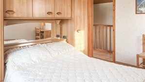 A bedroom with a bed, wooden wardrobe, and a small desk with a lamp. - 3 bedroom nice home in La Faute sur Mer (La Faute sur Mer)