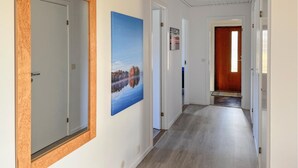 A hallway with wooden flooring, white walls, and doors leading to rooms. - Amazing home in Bolmsö with sauna (Bolmsö)