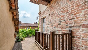 A narrow alley with a brick building, a wooden fence, and a vine-covered wall. - Awesome apartment in Aramengo AT (Aramengo AT)