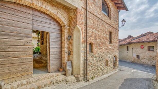 A narrow street with a traditional stone building featuring a wooden shuttered entrance and a small balcony. - Awesome apartment in Aramengo AT (Aramengo AT)