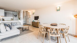 Eine moderne Wohnung mit Wohnzimmer, Essbereich, Küche und einer Wendeltreppe.