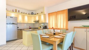 Una cocina moderna con zona de comedor, equipada con refrigerador, microondas y estufa.