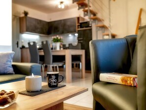 Una sala moderna con una mesa de centro, un libro y una vela.