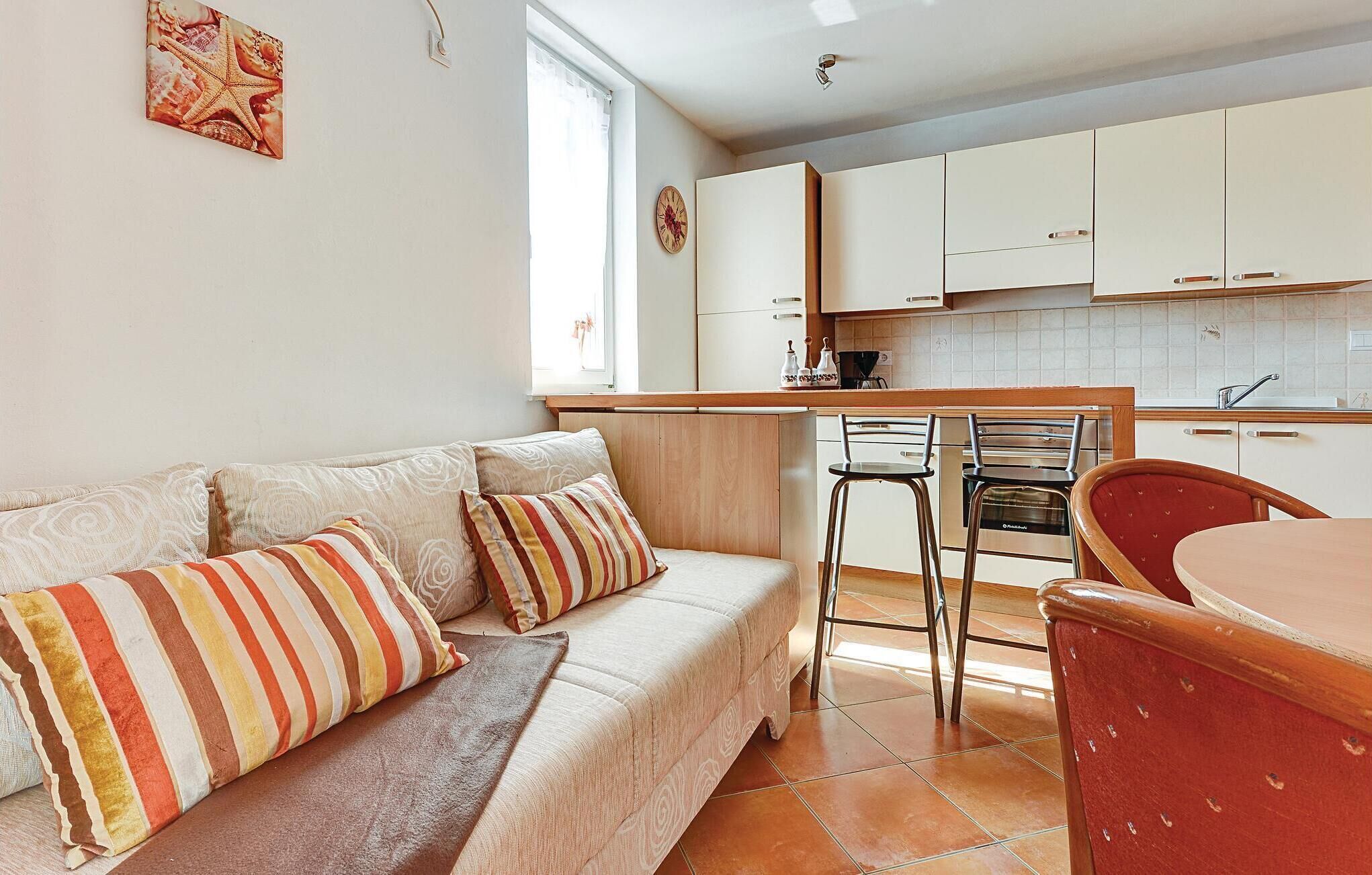 A compact living space with a sofa, a dining table, and a kitchen area.