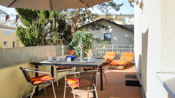 An outdoor patio with a table, chairs, and an umbrella. - Villa Malve Whg. 05 - VMa 05 (Heringsdorf)