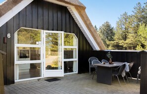 A wooden building with a large glass door and a thatched roof. - 4 bedroom awesome home in Rømø (Rømø)
