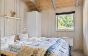 Une chambre à coucher avec un lit, une fenêtre et des murs en bois.