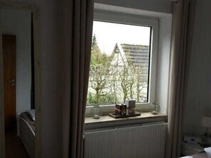 Une pièce avec une fenêtre, un radiateur et un lit.